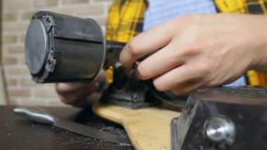 Close. Kırık elektrikli kaykayı tamir eden adam elleri. tekerlekleri söker