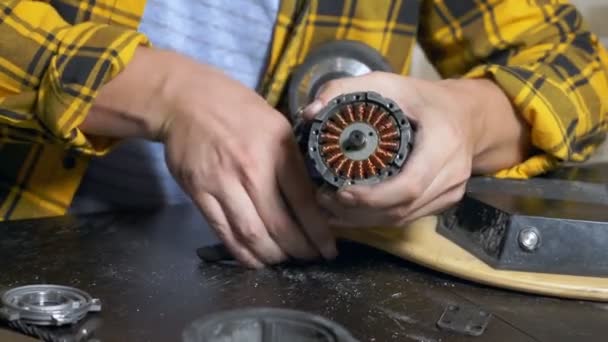 Mecânico reparando um motor elétrico de um patinete elétrico. rolamento de perto — Vídeo de Stock