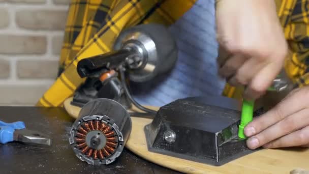 Μηχανικός επισκευής ηλεκτρικού κινητήρα ενός ηλεκτρικού πατινάζ. με κοντινό — Αρχείο Βίντεο