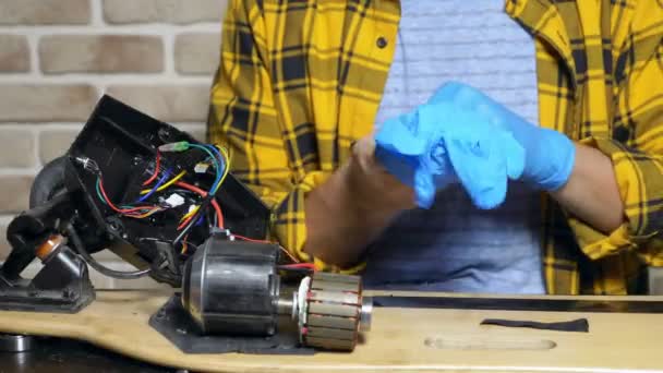 Mechaniker repariert einen Elektromotor eines elektrischen Schlittschuhs. Nahaufnahme — Stockvideo