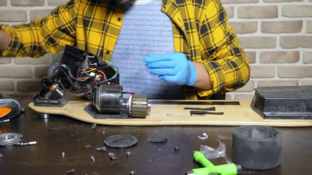 Mecânico reparando um motor elétrico de um patinete elétrico. rolamento de perto — Vídeo de Stock