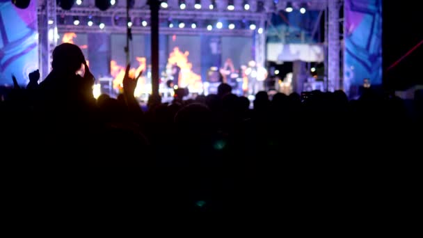 Rock concert in the evening. people in the crowd raise their hands and applaud. — Stock Video