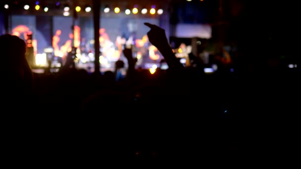 Rock concert in de avond. mensen in de menigte verhogen hun handen en juichen. — Stockvideo