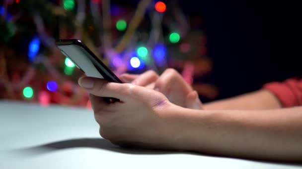 Feliz Ano Novo e Feliz Natal. close-up. mãos femininas SMS mensagem sms no smartphone — Vídeo de Stock