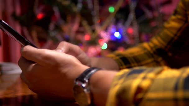 新年おめでとう、メリークリスマス。クローズ アップ。男性の手は、スマートフォン上のSMSメッセージをテキストメッセージ — ストック動画