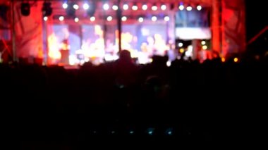 bulanık arka plan, fanlar siluetleri. akşam rock konseri. kalabalıktaki insanlar ellerini kaldırıp alkışlıyorlar..
