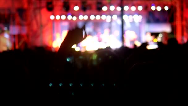 Fondo borroso, siluetas de los fans. concierto de rock en la noche. la gente en la multitud levanta la mano y aplaude . — Vídeo de stock