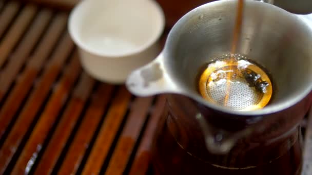 Traditionelle chinesische Teezeremonie. Nahaufnahme. Frauenhände gießen Tee in eine Teekanne — Stockvideo
