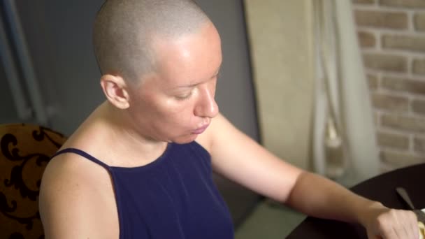 Nutrição adequada após quimioterapia. Mulher careca come em uma mesa na cozinha — Vídeo de Stock