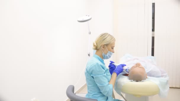 Microneedle RF-lyft förfarande. Hårdvara kosmetika. Kosmetolog genomför en ansikts föryngring förfarande för en skallig kvinna. — Stockvideo