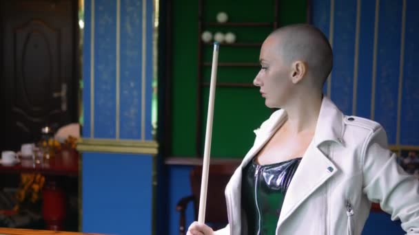 Portrait Beautiful stylish bald girl in a black leather corset and a white jacket next to a pool table. game of billiards. billiards club. — Stock Video