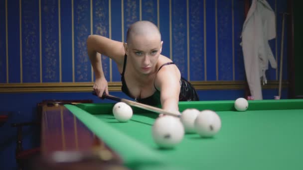 Stylish bald girl in a black leather corset plays billiards. — Stock Video