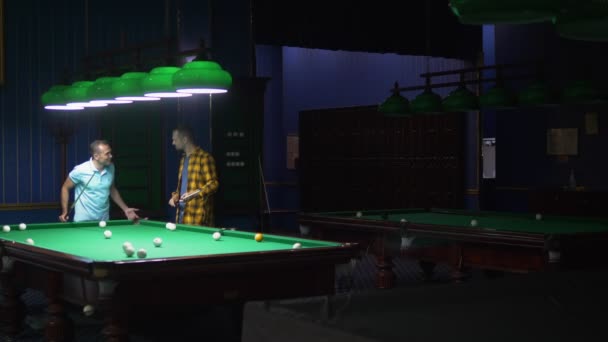 Два человека играют в бильярд в бильярдном клубе . — стоковое видео