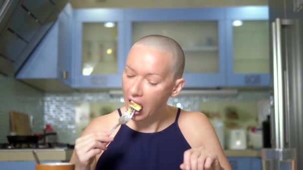 Σωστή διατροφή μετά από χημειοθεραπεία. Μια φαλακρός γυναίκα στο τραπέζι πίνει χάπια ενώ τρώει. — Αρχείο Βίντεο