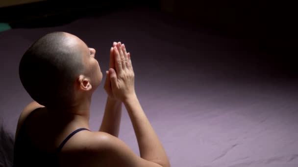 はげの女性がベッドの前でひざまずいて祈る。バックビュー。コピースペース — ストック動画