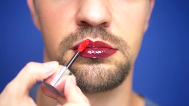 Close-up. a bearded man paints his lips. — Stock Video