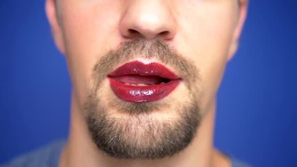 クローズ アップ。唇を塗ったあごひげの男が性的に舐める. — ストック動画