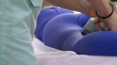 Mor takım elbiseli kel bir kıza lPG masajı yapılıyor..