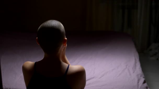 A bald woman prays on her knees by the bed. back view. copy space — Stock Video