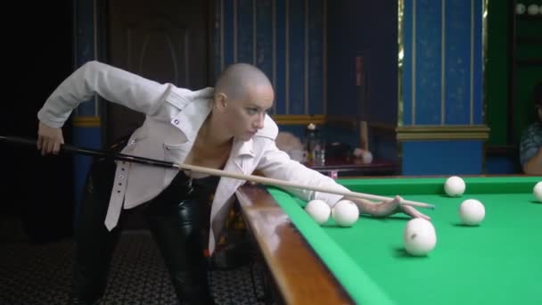 Élégante fille chauve dans une veste en cuir blanc joue au billard . — Video