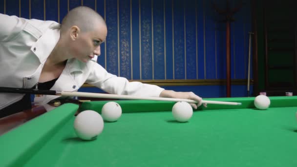 Élégante fille chauve dans une veste en cuir blanc joue au billard . — Video