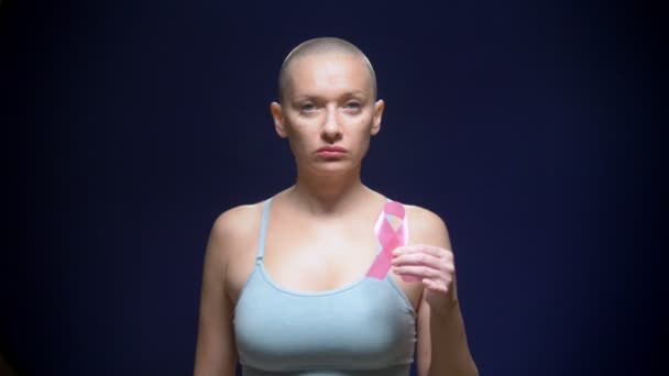 Лысая женщина на тёмном фоне. здравоохранение, люди и медицинская концепция - женщина с розовой лентой информированности о раке груди — стоковое видео