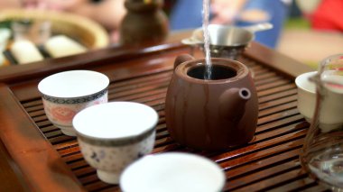 Traditional chinese tea ceremony. close-up. female hands pour boiling water into a kettle clipart