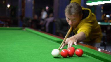 Genç erkek profesyonel bilardo oyuncusu bilardo oynuyor..
