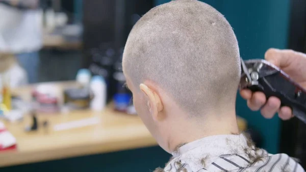 Koncept ztráty vlasů po chemoterapii. Kadeřník oholí zbytek vlasů na hlavě plešaté ženy, která přežila po chemoterapii. naděje na přežití. — Stock fotografie