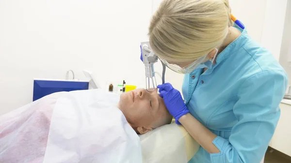 Doktor kosmetolog provádí zákrok laserového znovuobjevení obličeje. koncepce omlazení pleti, hardwarová kosmetologie. — Stock fotografie