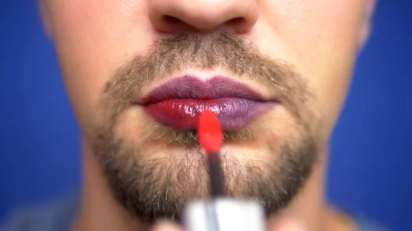 Närbild. en skäggiga man målar sina läppar. — Stockfoto