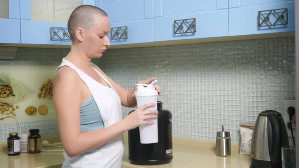 Cropped image of beautiful young sportswoman showing Ok sign while preparing sport nutrition in kitchen at home — Stock Photo, Image