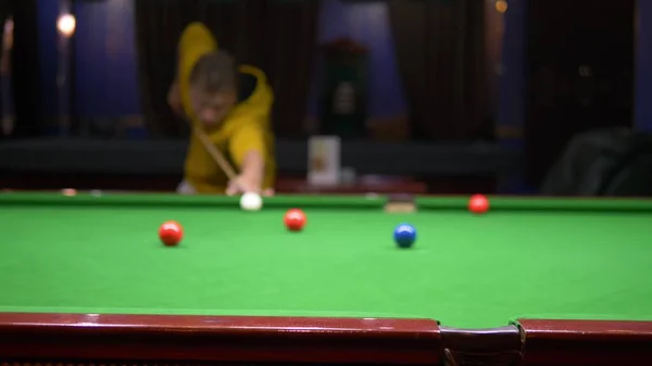 young male professional pool player playing snooker.