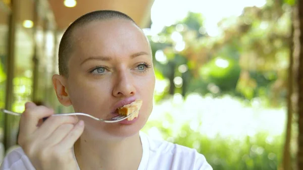 Hermosa joven calva almorzando en un café al aire libre . — Foto de Stock