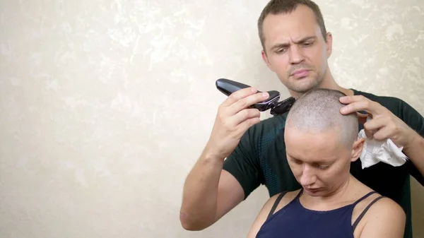 Mannen rakar huvudet av en skallig kvinna. kopiera utrymme. äventyr av främmande människor — Stockfoto