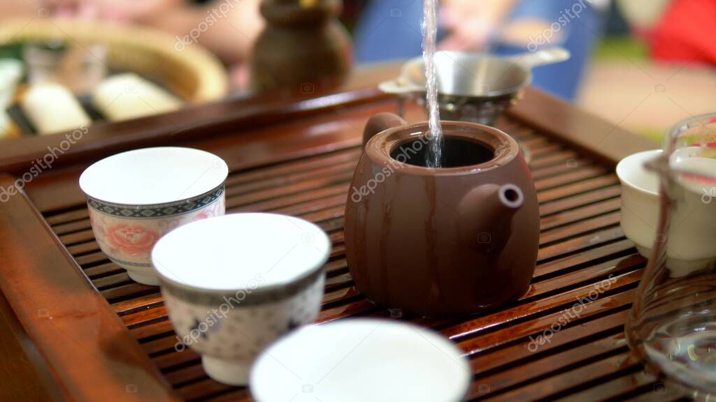 Traditional chinese tea ceremony. close-up. female hands pour boiling water into a kettle