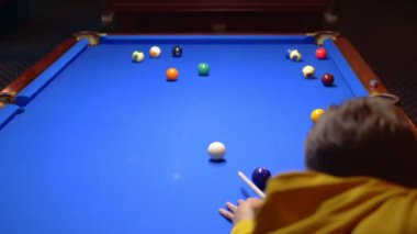Genç erkek profesyonel bilardo oyuncusu bilardo oynuyor..