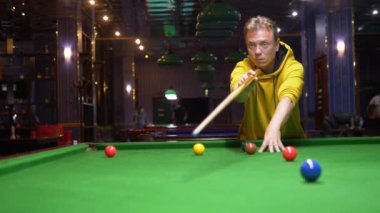 Genç adam, profesyonel bilardo oyuncusu Amerikan bilardosu oynuyor..