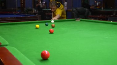 Genç adam, profesyonel bilardo oyuncusu Amerikan bilardosu oynuyor..