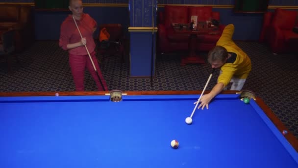 Paar, Mann und Frau mit Glatze spielen amerikanisches Billard. — Stockvideo