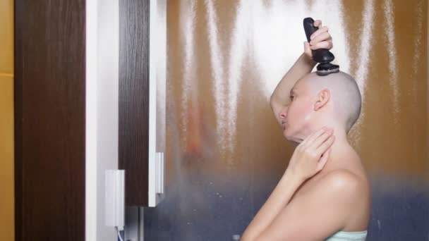 Μια φαλακρή γυναίκα ξυρίζει το κεφάλι της στο μπάνιο μετά το ντους. Αντιγραφή χώρου. περιπέτειες παράξενων ανθρώπων — Αρχείο Βίντεο