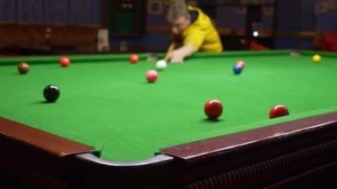 Genç adam, profesyonel bilardo oyuncusu Amerikan bilardosu oynuyor..