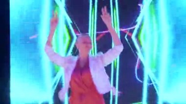 Kulüp partisi. Gece hayatı. Neon ışıklı diskonun renkli ışınlarında dans eden kel, güzel bir kız.