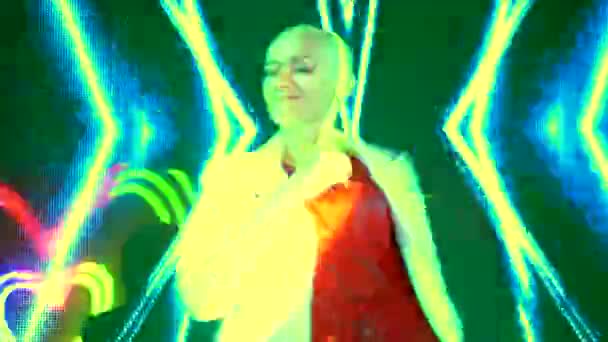 Πάρτι κλαμπ. Νυχτερινή ζωή. φαλακρή όμορφη κοπέλα χορεύει σε ένα κλαμπ στις πολύχρωμες ακτίνες ενός νέον φώτα ντίσκο — Αρχείο Βίντεο