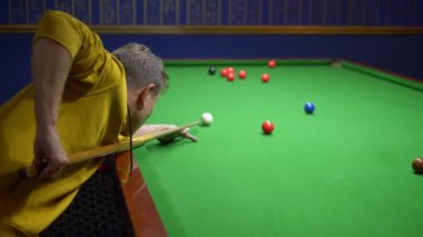 Genç adam, profesyonel bilardo oyuncusu Amerikan bilardosu oynuyor..