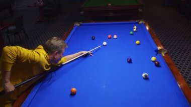 Genç adam, profesyonel bilardo oyuncusu Amerikan bilardosu oynuyor..