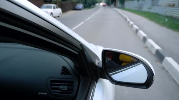 Zijspiegel van een auto tijdens het rijden op een snelweg. — Stockvideo