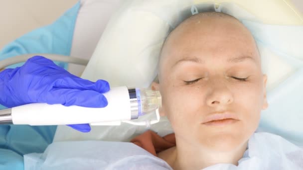 Närbild. Microneedle RF-lyft förfarande. Hårdvara kosmetika. Kosmetolog genomför en ansikts föryngring förfarande för en skallig kvinna. — Stockvideo
