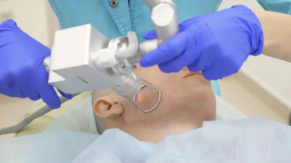 Ο γιατρός αισθητικός κάνει τη διαδικασία της επανακτινοβολίας του προσώπου. αίσθηση αναζωογόνησης του δέρματος, υλικό κοσμετολογία. — Φωτογραφία Αρχείου