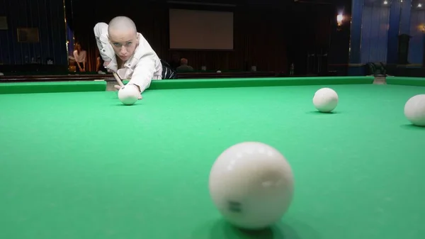 Élégante fille chauve dans une veste en cuir blanc joue au billard . — Photo